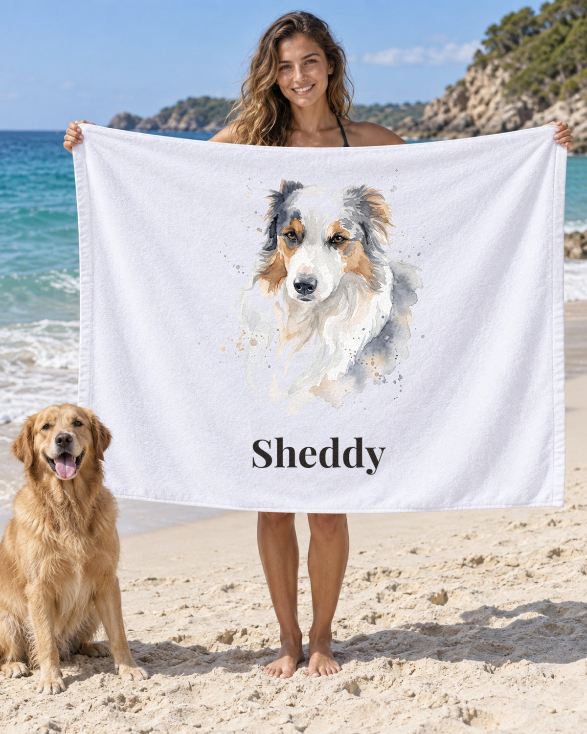 Weißes Badetuch mit Hundeportrait im Stil Aquarell und dem Namen Sheddy, eine Frau hält es am Strand, ihr Hund sitzt daneben