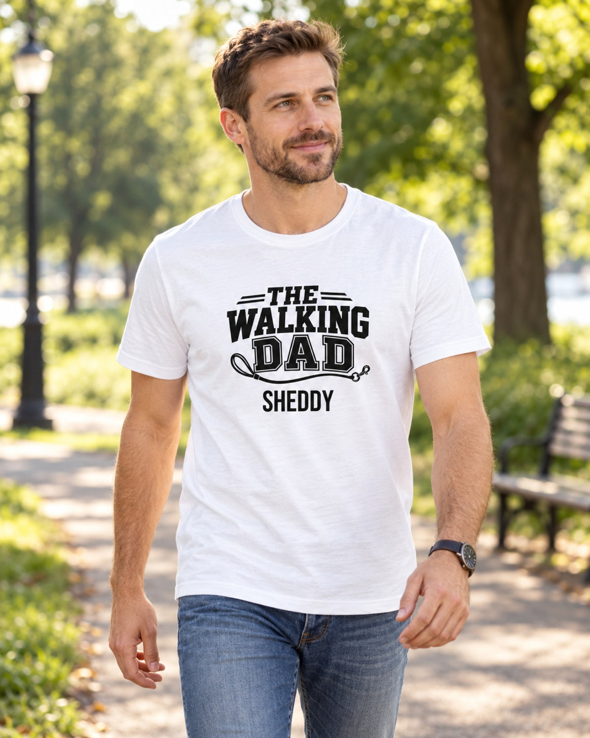 Mann im weißen T-Shirt „The Walking Dad“ mit Hundenamen beim Spaziergang