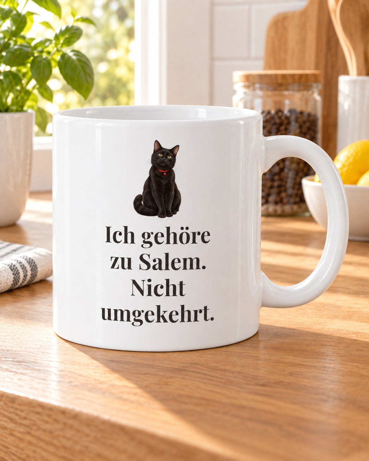 Weiße Katzentasse mit schwarzer Katze und Spruch Ich gehöre zu Salem. Nicht umgekehrt., auf dem Küchentisch
