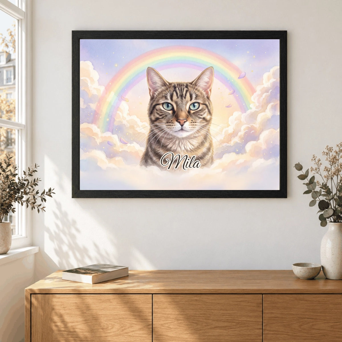 Rainbow Bridge memorial portrait in a black wooden frame: Mila the cat beneath a rainbow in the clouds, with name