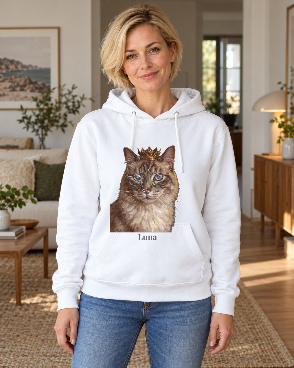 Hoodie in Hellblau mit Portrait von einer Ragdoll im Stil Royal und dem Namen Luna, getragen von einer Frau in einer hellen Wohnung